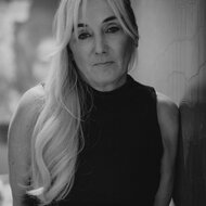 Black-and-white portrait of a woman leaning against a wall