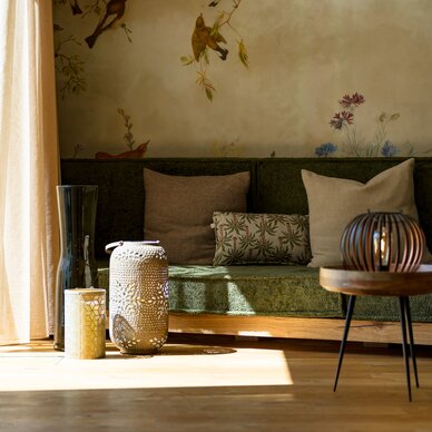Sunlit living room with green sofa and lanterns