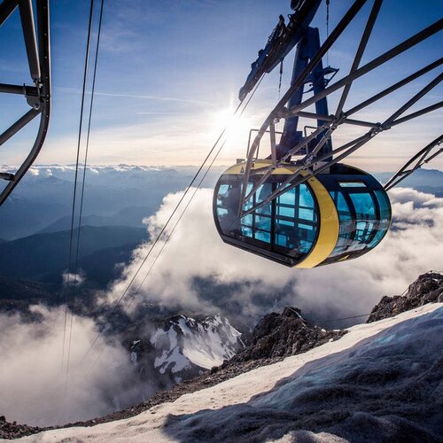 Seilbahn-Gondel fährt über Schnee und Wolken im Gebirge