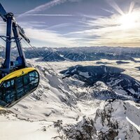 Gelbe und blaue Gondel über schneebedeckten Bergen, Der Dachstein
