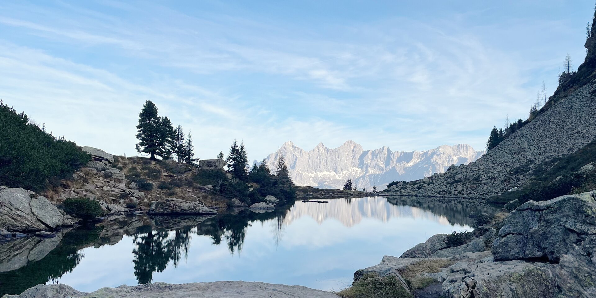 Bergsee umgeben von Felsen und Tannen