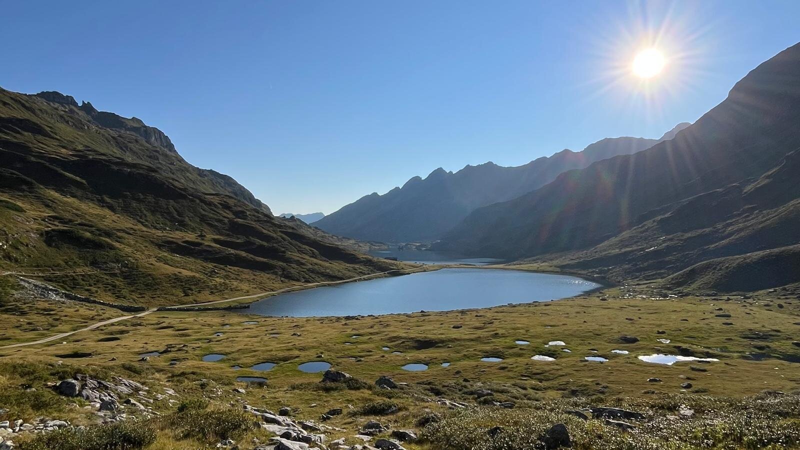 Sonnenlicht über einem Bergsee im Tal