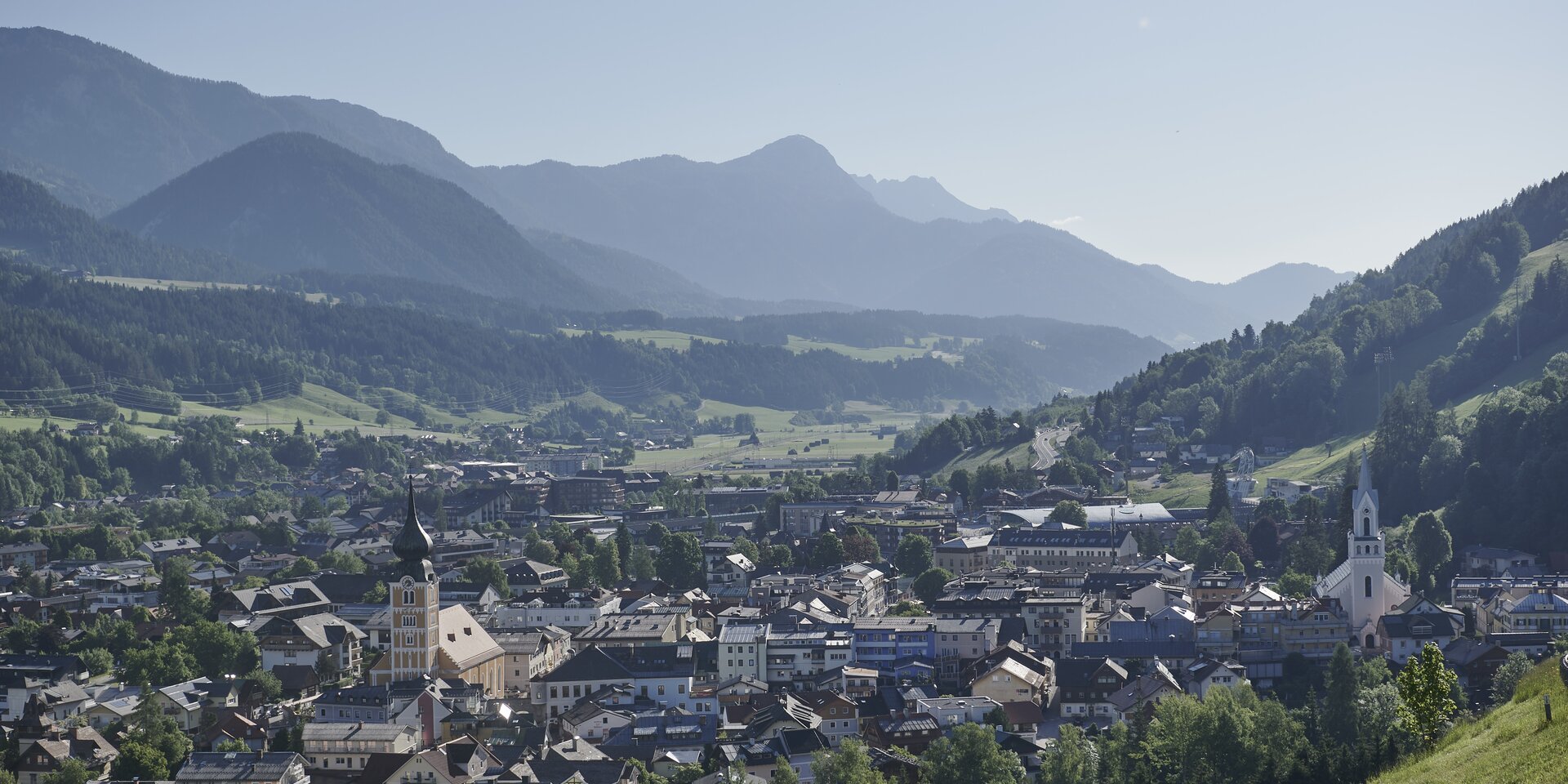 Small town nestled in a valley with distant mountains