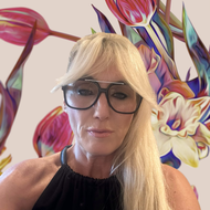 Blonde woman with glasses in front of vibrant mural