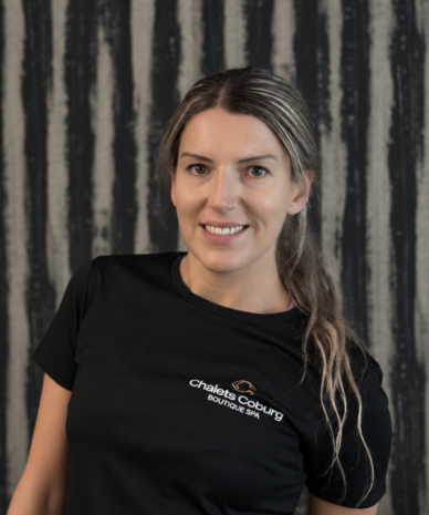 Smiling woman in black Chalets Coburg Boutique Spa shirt
