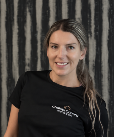 Lächelnde Frau in schwarzem Chalets Coburg Boutique Spa Shirt