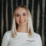 Smiling woman wearing a white shirt with Schladming Apartments logo