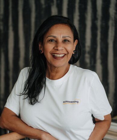 Lächelnde Frau trägt weißes T-Shirt mit Schladming-Logo