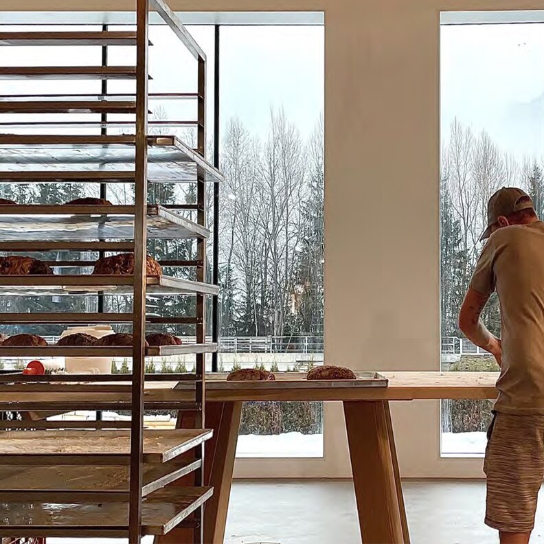 Mitarbeiter sortiert Brot auf einem Holztisch in der Bäckerei