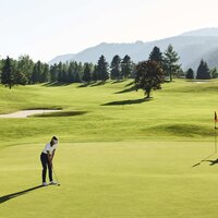 Zwei Golfer auf einem üppigen, weiten Golfplatz