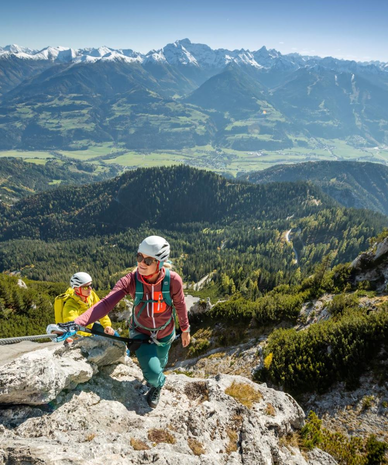 Zwei Bergsteiger steigen einen felsigen Bergpfad mit Sicherheitsseil. | © Marion Omulec | Schladming-Dachstein