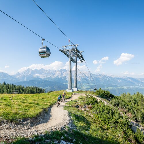 Seilbahngondel über Berglandschaft mit Radfahrern | © Christoph Oberschneider