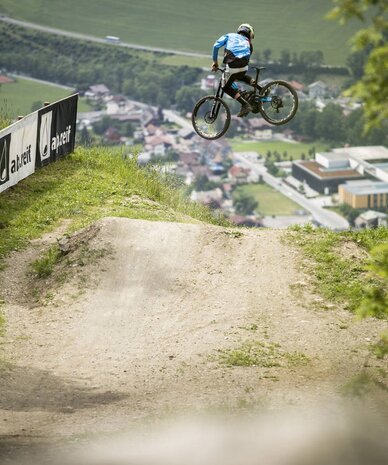Mountainbiker in der Luft über Erdrampe am Hang | © Roland Haschka/Young Mountain Marketing