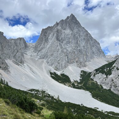 Schmaler Wanderpfad windet sich zum rauen Alpengipfel.