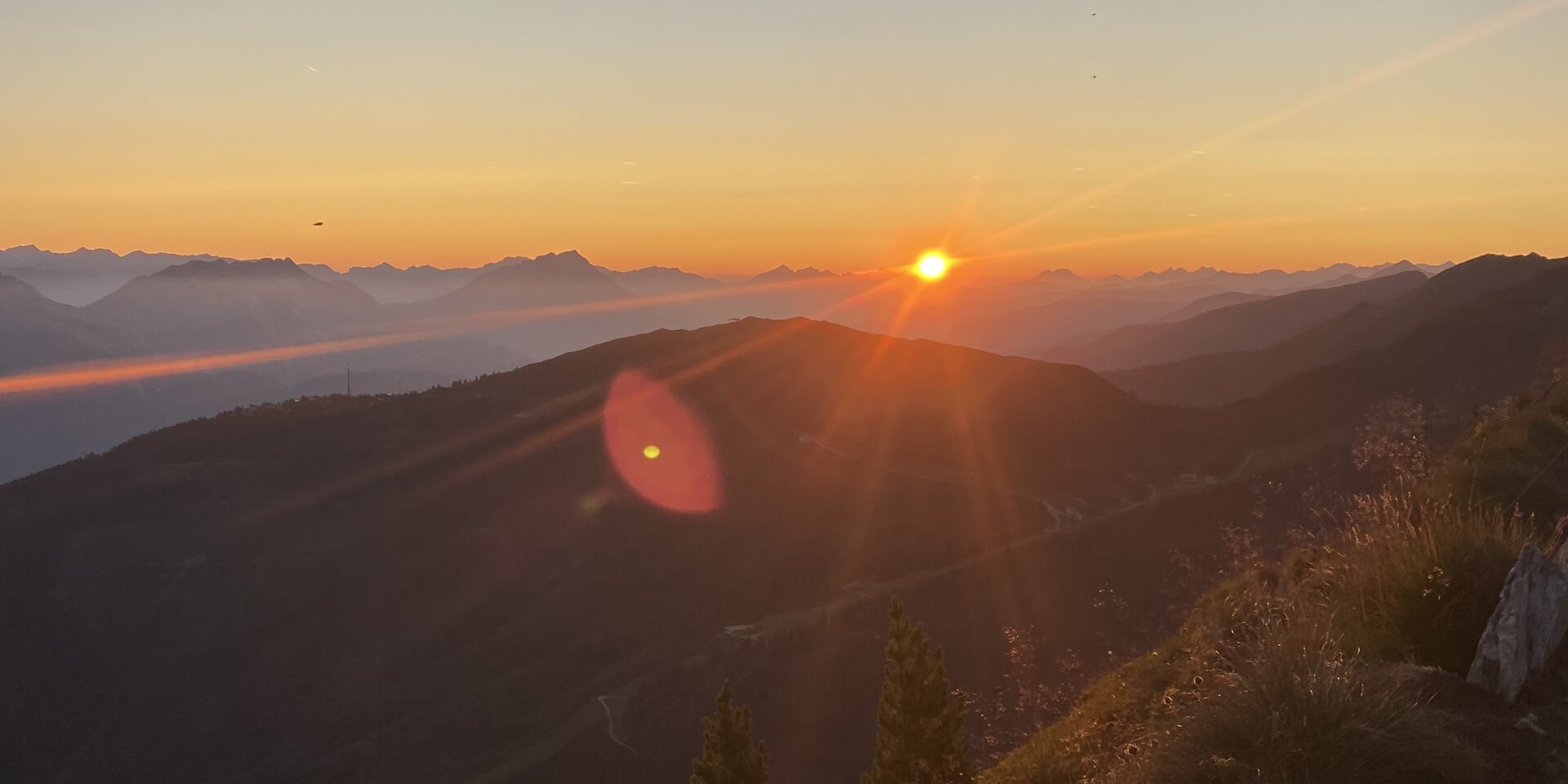 Sonnenuntergang über Bergkette mit rotem Himmel
