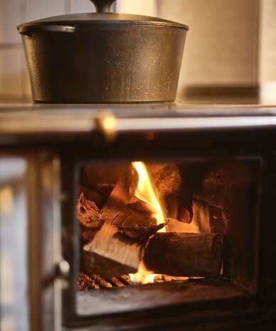 Gusseiserner Topf auf dem Herd über glühenden Flammen | © RAPHAELGABAUER.COM