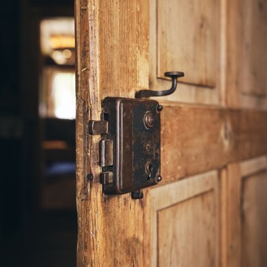 Verrostete Türverriegelung an einer alten Holztür | © RAPHAELGABAUER.COM