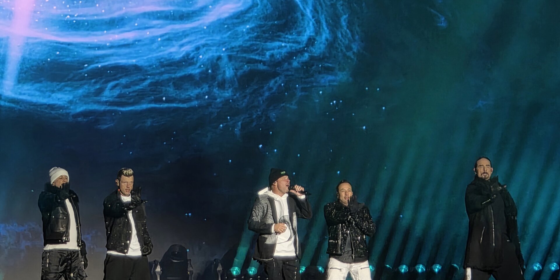 Group of male singers performing on a brightly lit stage