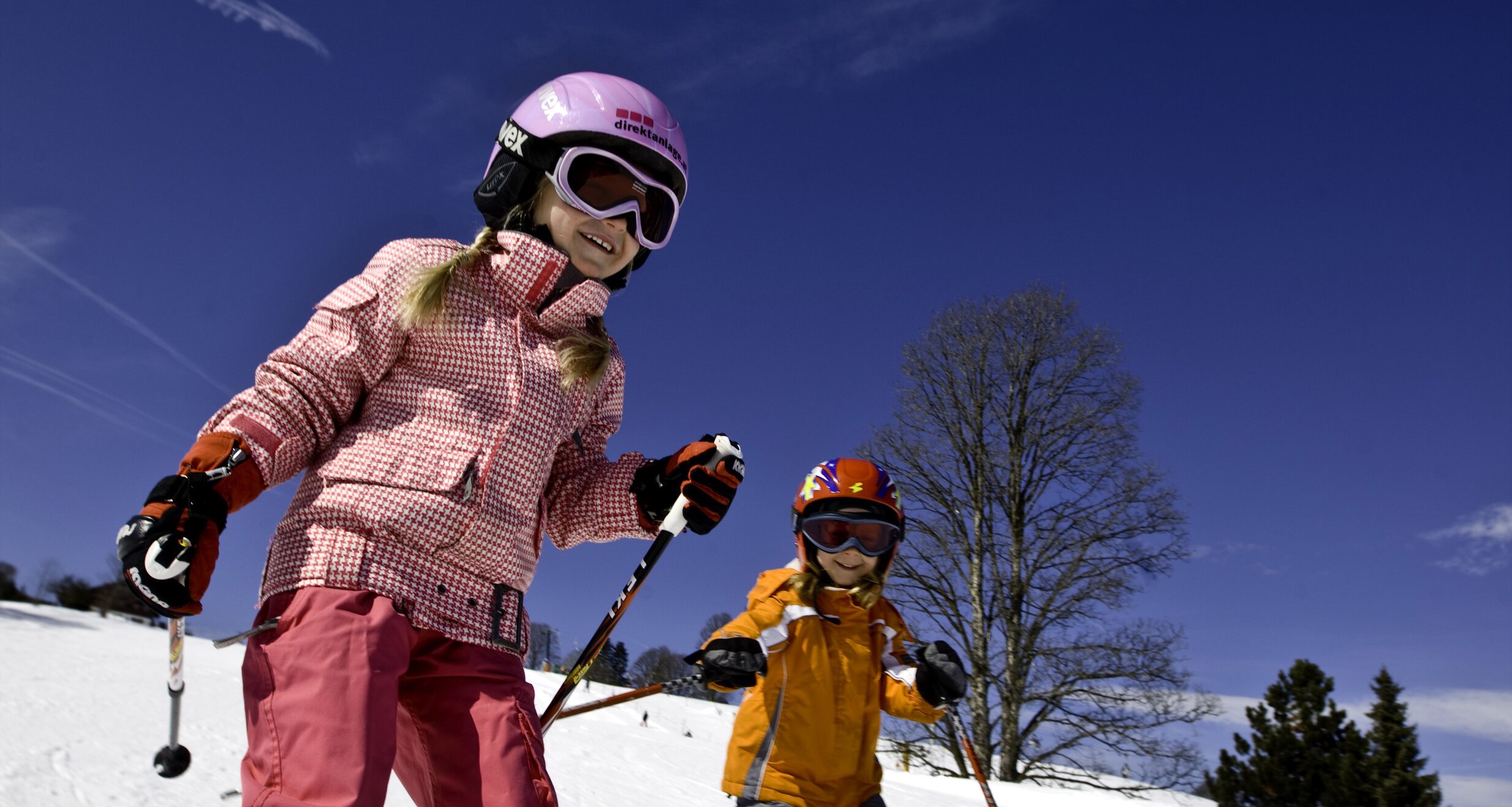 Zwei Kinder beim Skifahren auf schneebedeckter Skipiste. | © Tom Lamm