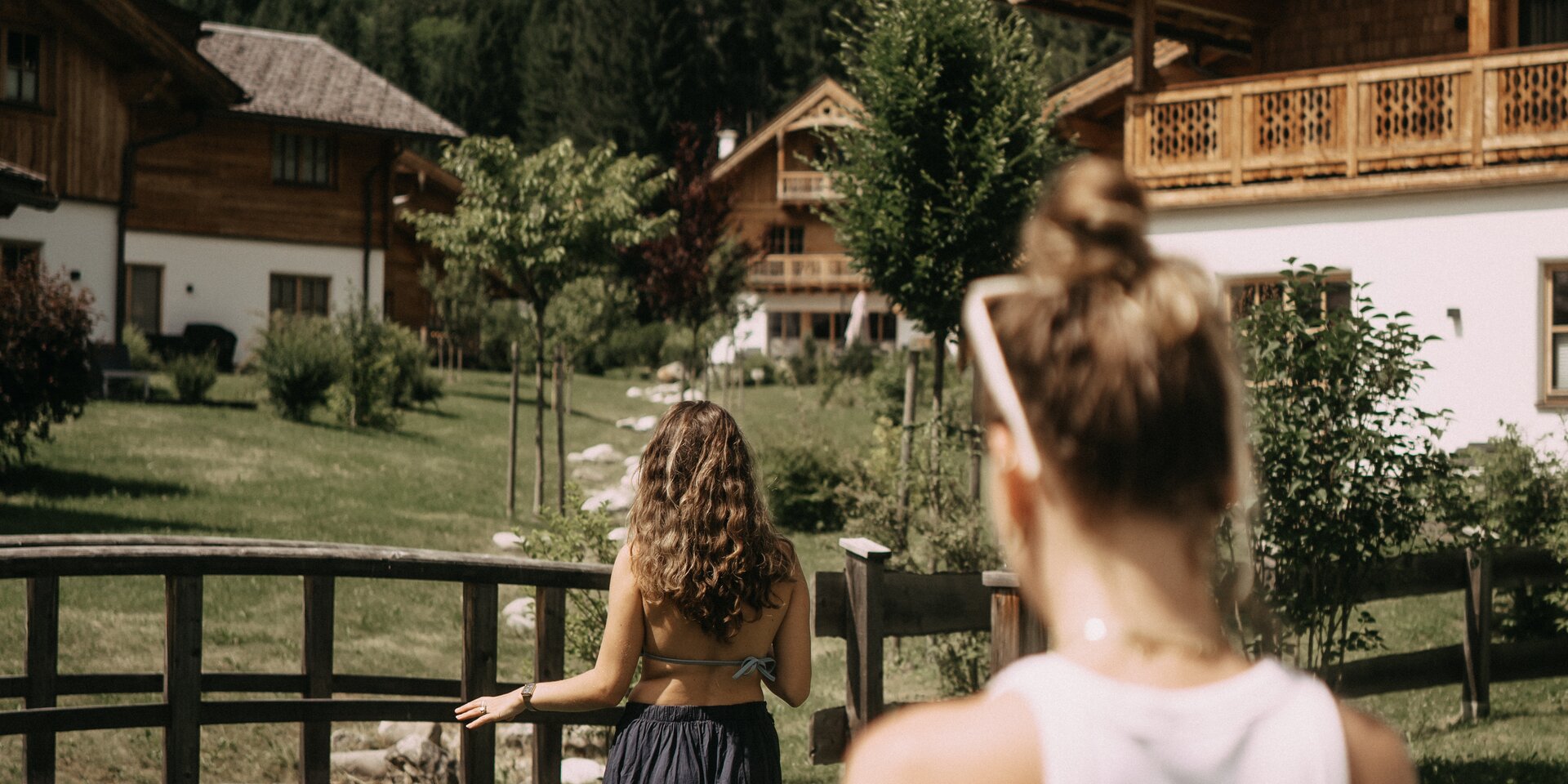Zwei Frauen in einem Bergdorf mit Holzhäusern