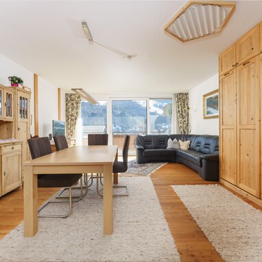 Wohnzimmer mit Holzmöbeln, Esstisch und Ledersofa