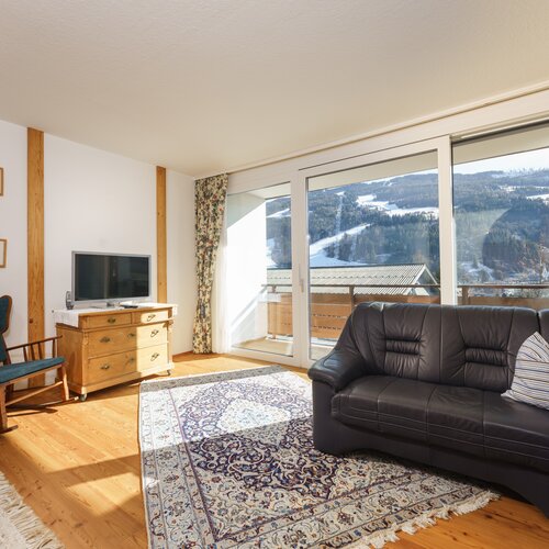 Wohnzimmer mit großen Glasfronten und Bergblick