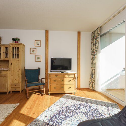 Helles Wohnzimmer mit Holzmöbeln und Fernseher