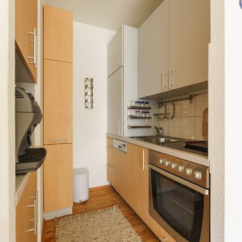 Kleine Küche mit Holzfronten, Ofen und Spüle