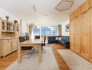 Heller Wohn- und Essbereich mit Holzmöbeln und Bergsicht