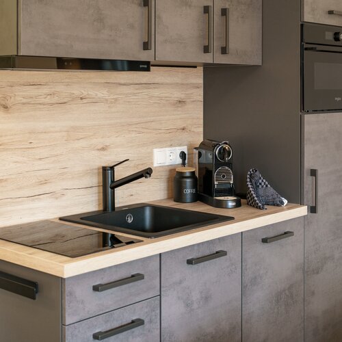 Moderne Küche mit Spüle, Kaffeemaschine und Schränken