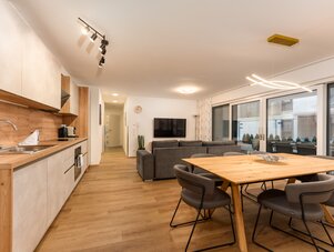 Open-concept kitchen, dining area, and living room with glass doors