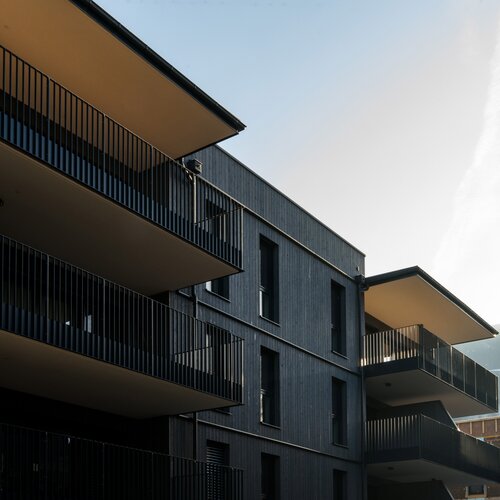Modern dark apartment building with multiple balconies