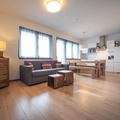 Offener Wohnbereich mit Sofa, Esstisch und Holzmöbeln