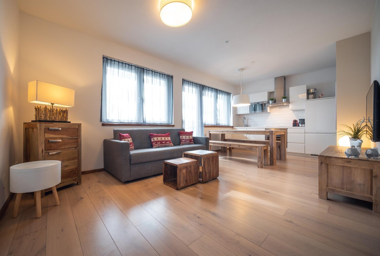 Offener Wohnbereich mit Sofa, Esstisch und Holzmöbeln