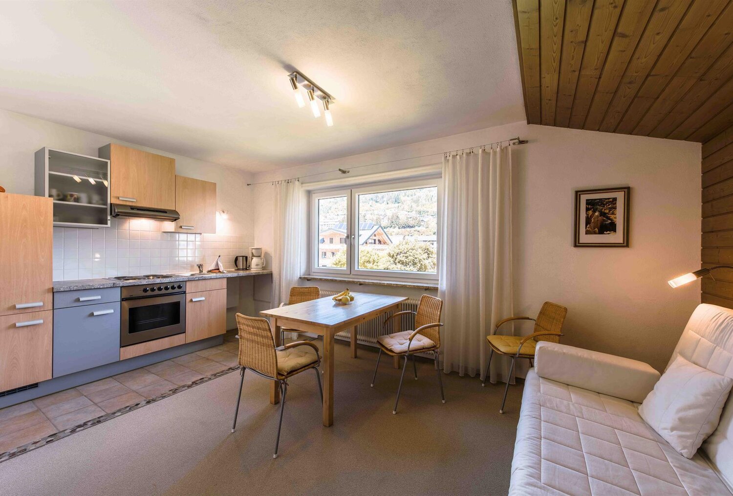 Küche und Essbereich mit Holzbalkendecke und Fenster