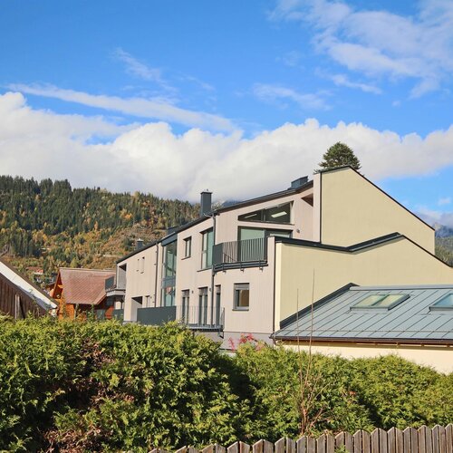 Modern residential buildings along a hillside with mountains