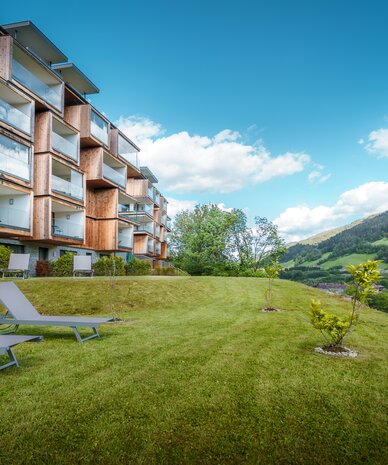 Modern wooden apartment building with glass balconies and lawn | © Tieber Michael