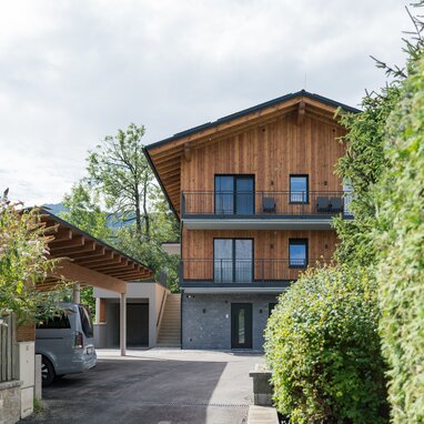 Holzhaus mit Balkonen und Grün