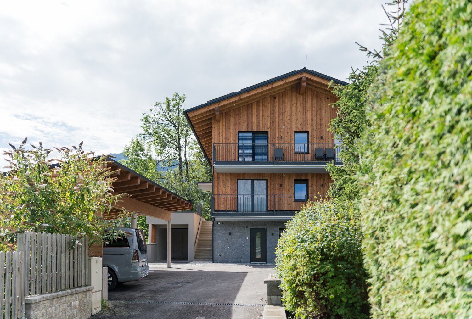Holzhaus mit Balkonen und Grün