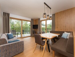Wohnzimmer mit Holzpaneel-Wänden und großen Glasfronten