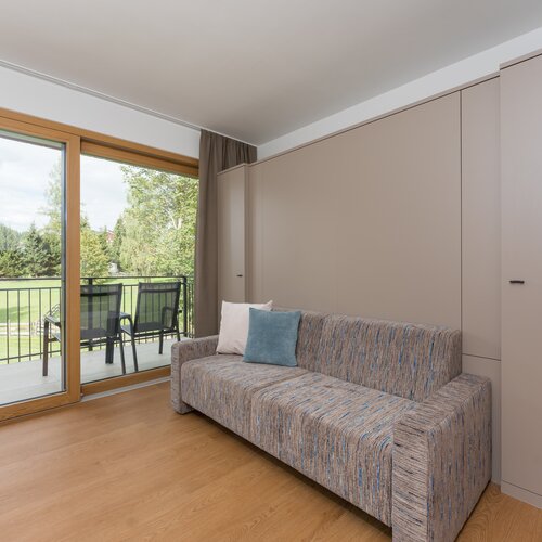 Wohnzimmer mit beigen Einbauschränken und Couch nahe Glastür