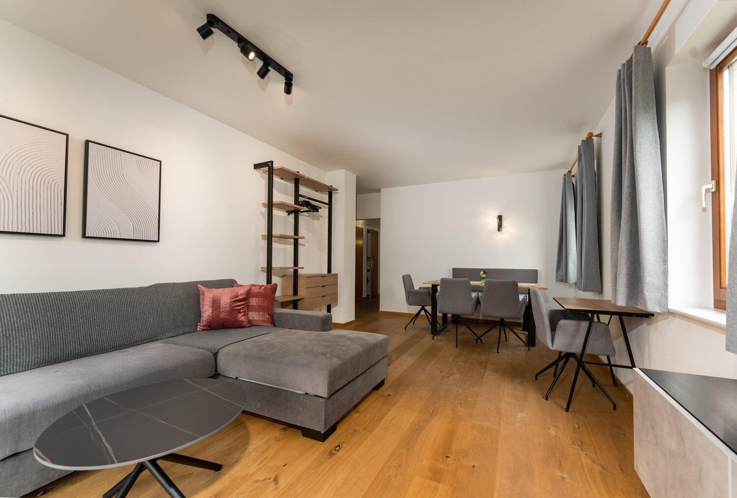 Graue Eckcouch mit pinken Kissen im Wohnzimmer