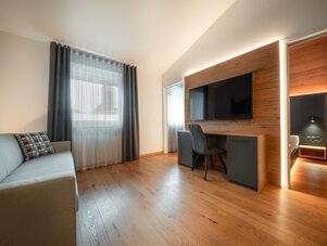 Modernes Hotelzimmer mit Sofa, Schreibtisch und TV