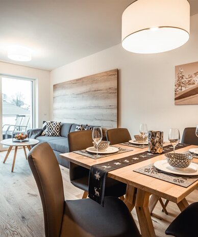 Offener Wohn- und Essbereich mit verschneitem Balkonblick