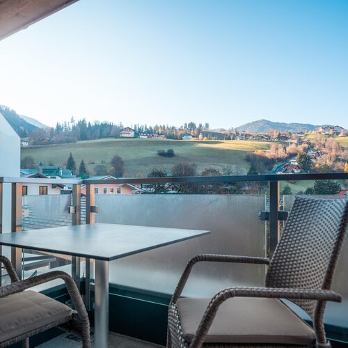 Balkon mit zwei Korbstuehlen und Tisch, Blick auf Landschaft | © TIEBER