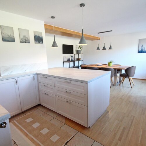 Helle Küche mit Marmorarbeitsplatten und Essbereich | © SCHLADMING-APPARTEMENTS