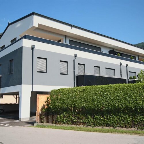 Modernes graues und weißes Mehrfamilienhaus mit Hecke