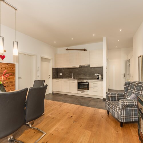 Offener Wohn- und Essbereich mit Holztisch und schwarzen Stühlen