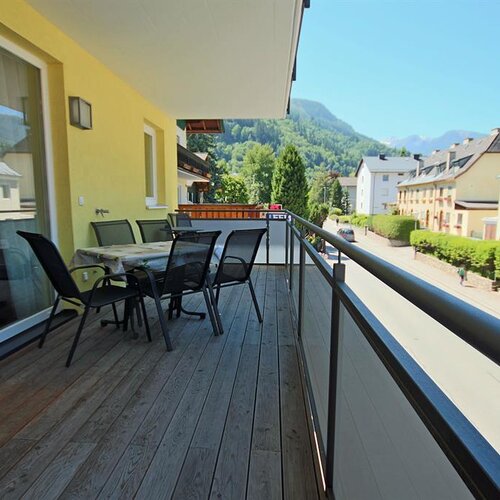 Balkon mit Esstisch und Stühlen, Blick auf Straße und Berge