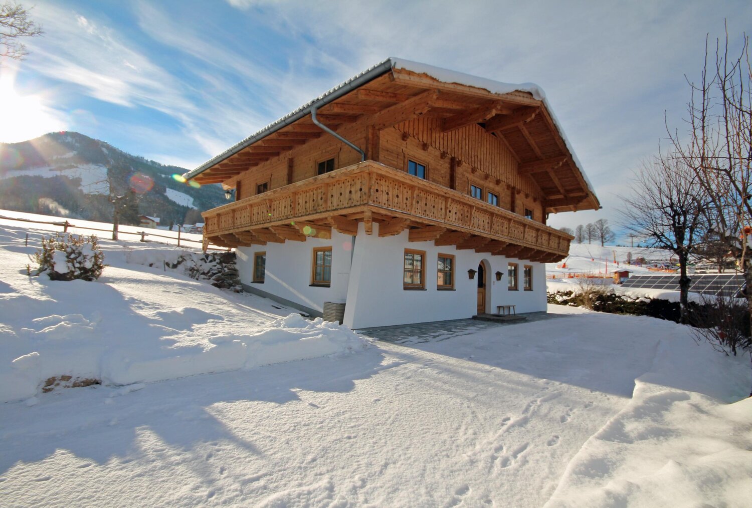 Snowy alpine chalet with large wooden balcony